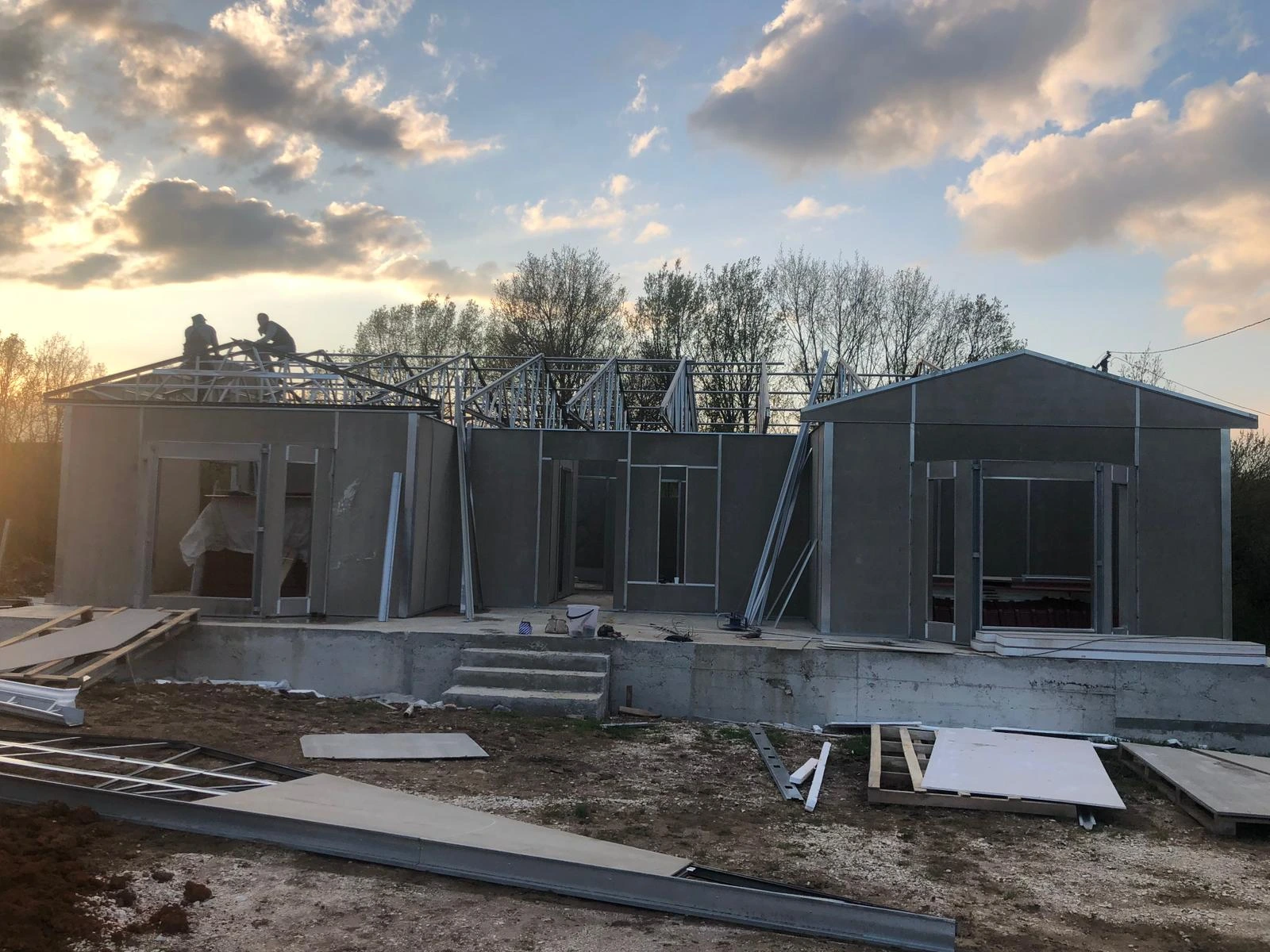 Çelik konstrüksiyon çatısı monte edilen prefabrik ev yapım süreci. Betonarme temel üzerinde hızlı ve güvenli montaj.