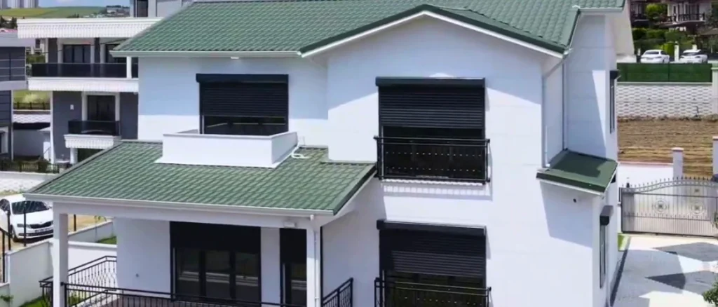 Şehir içinde balkonlu, yeşil çatılı modern çelik ev